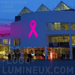 Projektion rosa Lichtband auf Gebäudefassade zur Krebsaufklärung