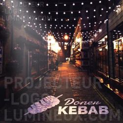 Illuminated sign for economical Kebab by projection on the sidewalk