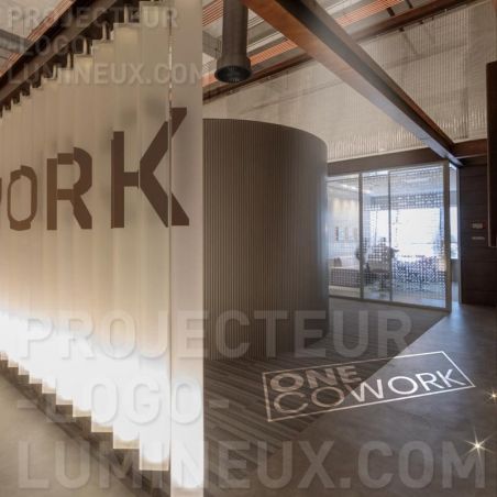 Proyección de logotipo iluminado en el suelo recepción coworking