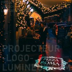 Luminous logo for pizzeria projected on the ground on sidewalk