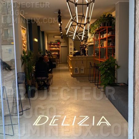 Proiezione del logo illuminato sul pavimento dell'ingresso del ristorante