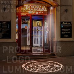Light advertisement projected on the street floor for Restaurant Pizzeria